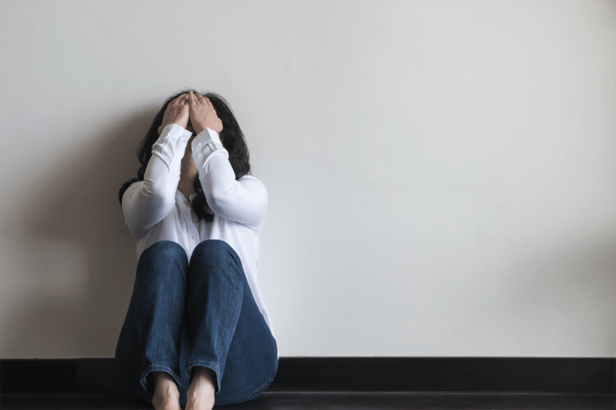 Woman on the floor with anxiety.