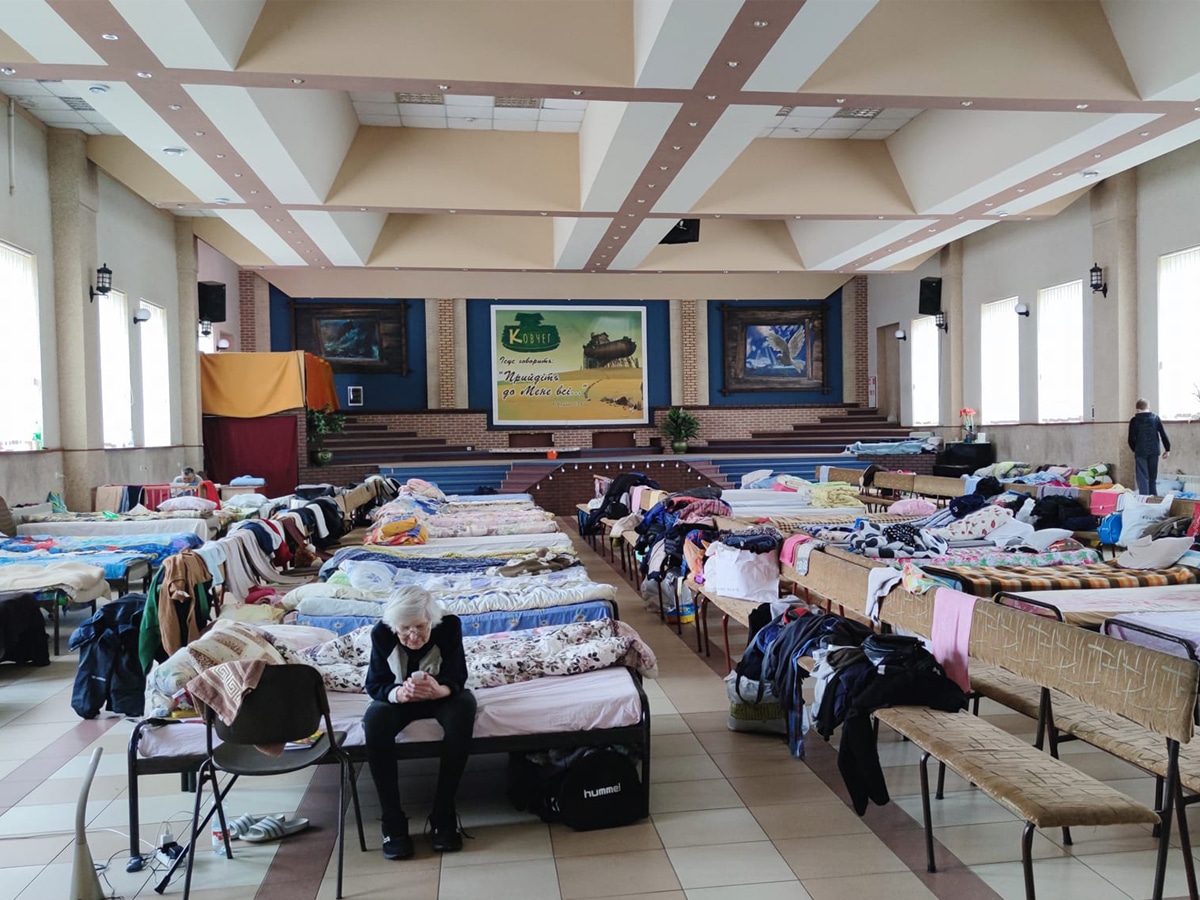 Many beds next to eachother in one large room.