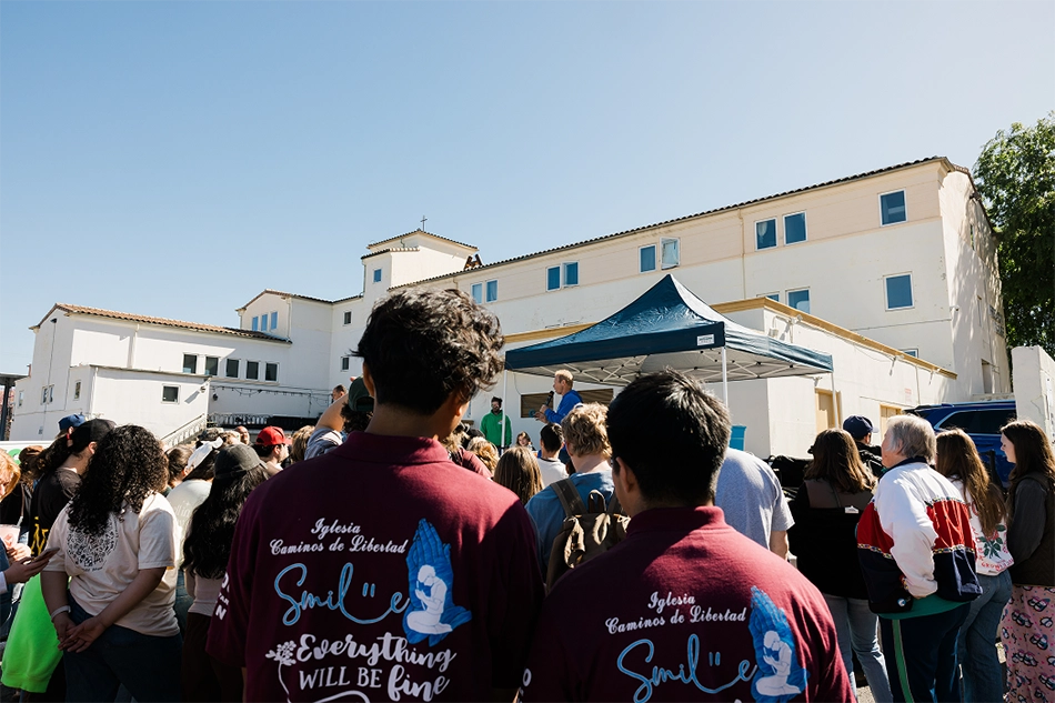Crowd gathered outside a church building under a blue canopy, representing CityServe’s collaboration with churches, nonprofits, and leaders to serve communities in need.