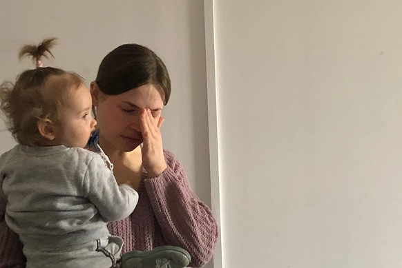 Ukrainian mother holding her baby at a CityServe Family Center in Kyiv, receiving emotional and practical support through local church outreach.