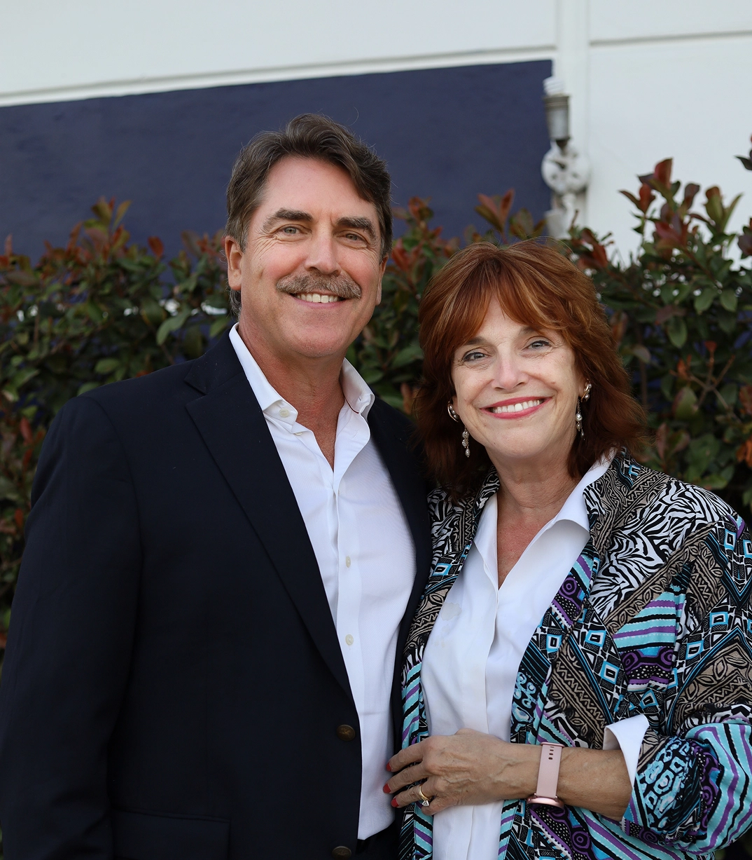 Dave and Ruscell Pavlin, CityServe Board of Directors Secretary, smiling outdoors in front of greenery.